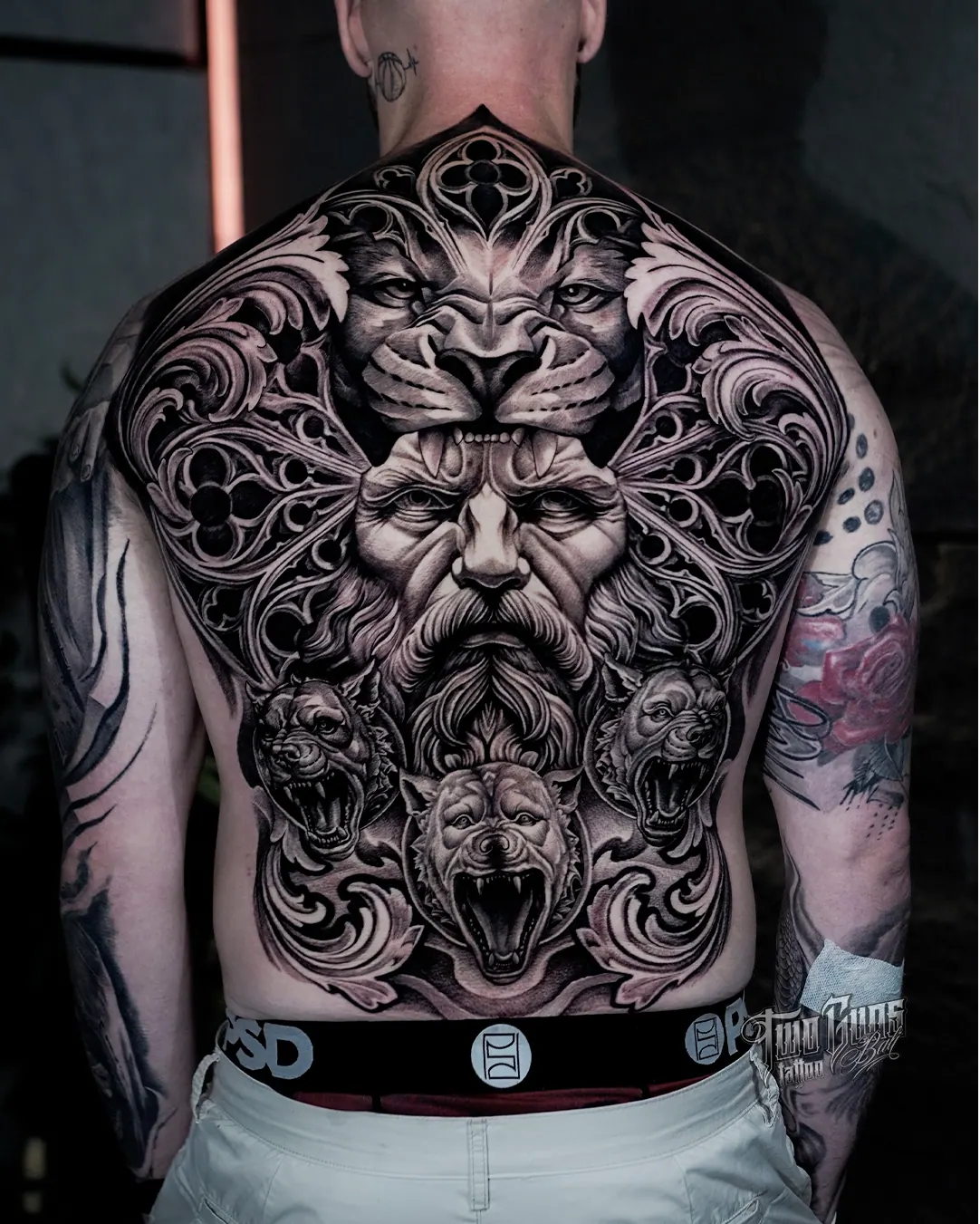 Black and grey ornamental full back tattoo of layered lion and demon faces